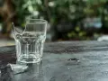 Rozbite szklanki leżą na ciemnym blacie. Pytanie, gdzie wyrzucać szklanki, staje się aktualne.