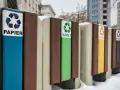 Segregacja odpadów w firmie: pojemniki na papier, szkło, plastik i inne. Zimowy krajobraz miejski.