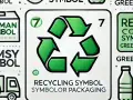 Centralny znak recyklingu na opakowaniach, otoczony innymi symbolami i butelkami.