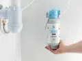 Dłoń trzyma wkład filtrujący do systemu Flow Comfort. Pokazuje, jak działa filtr do wody, zapewniając smaczną wodę prosto z kranu.