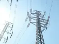 Wysokie słupy energetyczne z przewodami, przypominające o potrzebie oszczędzania i rozsądnym zarządzaniu abonamentem za prąd.