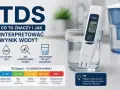 Miernik TDS w szklance wody pokazuje 128 ppm. Obok tabela interpretacji wyników TDS, wskazująca, że najlepsza woda do picia ma 50-300 ppm.