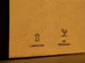 Na brązowym opakowaniu widnieje znak opakowanie biodegradowalne. Obok symbolu jabłka i napisu "COMPOSTABLE" znajduje się symbol kiełkującej rośliny z napisem "BIO DEGRADABLE".