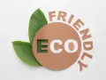 Znak e na opakowaniu z napisem "ECO FRIENDLY" i zielonymi liśćmi.