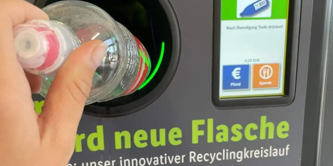 Ręka wrzuca butelkę do automatu, który jest częścią systemu kaucyjnego w Niemczech. Na ekranie widać flagi, symbol butelki i opcje zwrotu kaucji.