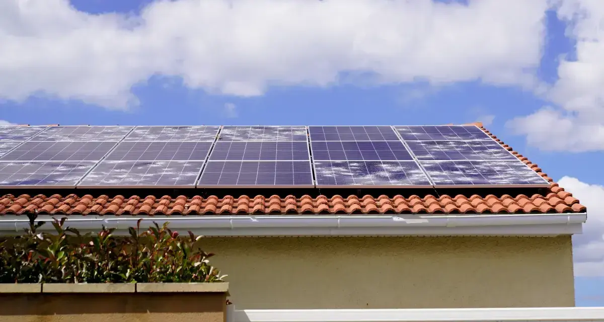 Panele fotowoltaiczne na dachu z dachówką. Zastanawiasz się nad ubezpieczeniem fotowoltaiki na gruncie? Zabezpiecz swoją inwestycję!