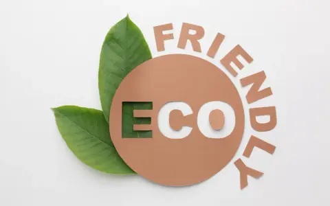 Znak e na opakowaniu z napisem "ECO FRIENDLY" i zielonymi liśćmi.