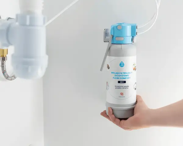 Dłoń trzyma wkład filtrujący do systemu Flow Comfort. Pokazuje, jak działa filtr do wody, zapewniając smaczną wodę prosto z kranu.