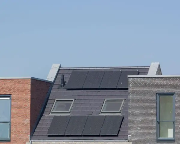 Nowoczesne dachy z panelami fotowoltaicznymi, które zapewniają zieloną energię. Domy z cegły i dachówką, z oknami dachowymi.