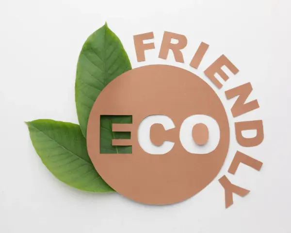 Znak e na opakowaniu z napisem "ECO FRIENDLY" i zielonymi liśćmi.
