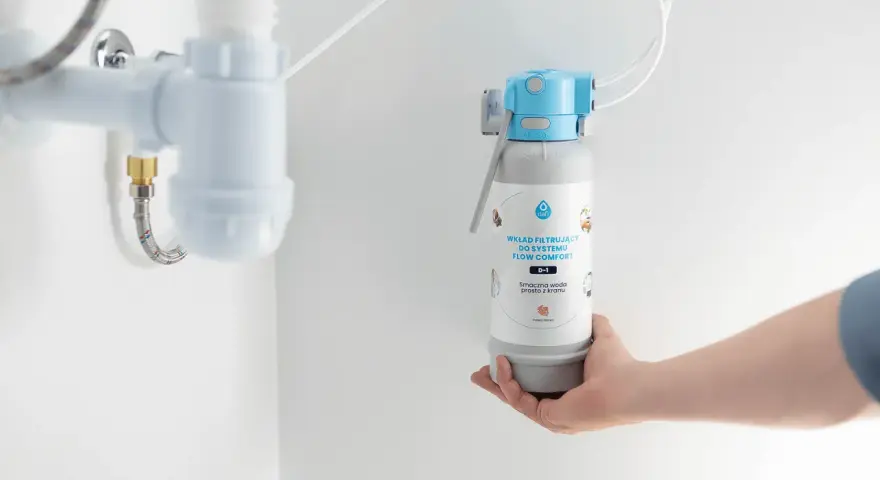Dłoń trzyma wkład filtrujący do systemu Flow Comfort. Pokazuje, jak działa filtr do wody, zapewniając smaczną wodę prosto z kranu.