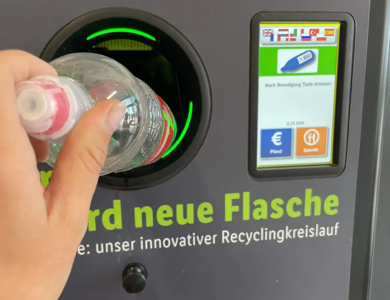 Ręka wrzuca butelkę do automatu. Niemiecki system kaucyjny działa sprawnie, zwracając 0,25 EUR za każdy zwrot.